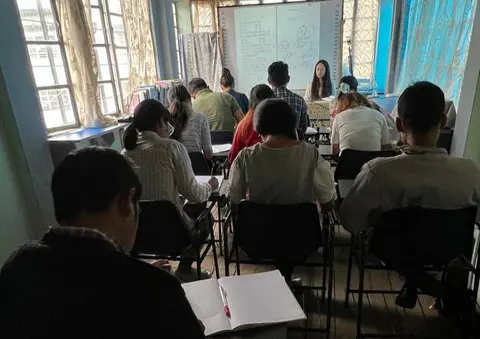 Learners seated in a KSLC classroom facing the teacher and whiteboard